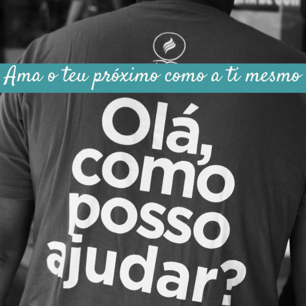 Um homem usa uma camisa que diz "Como Posso Ajudar"? e a foto é legendada por a palavras: Ama o teu próximo como a ti mesmo.