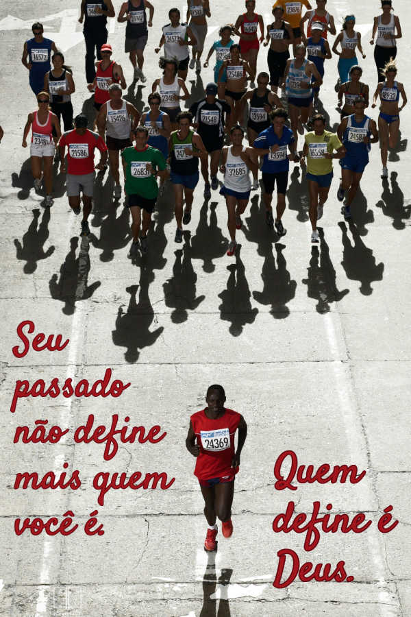 Uma fotografia registra uma corrida de rua, com um corredor de camiseta vermelha à frente de um grande grupo de competidores. Uma inscrição em letras vermelhas diz: “Seu passado não define quem você é; quem define você é Deus”, enquanto cones alaranjados, números de peito, sombras longas e o pavimento rachado compõem o cenário.