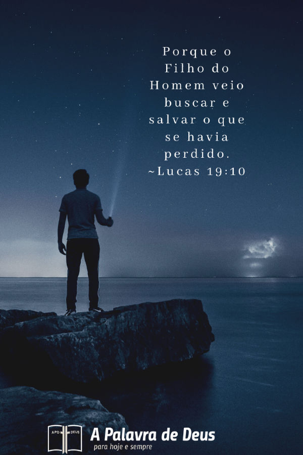 Um homem está à beira de um lago apontando uma lanterna para o céu estrelado da noite. Lucas 19:10