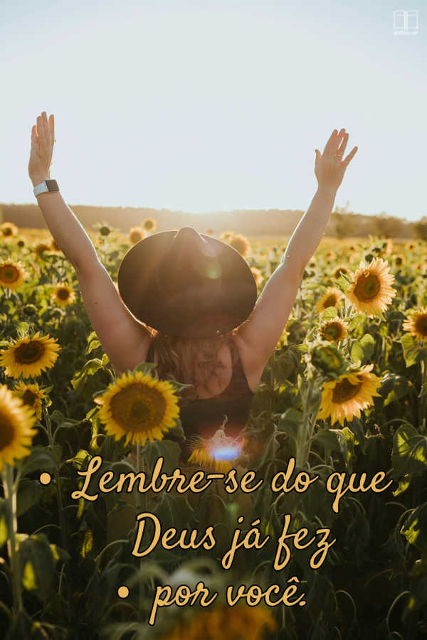 Deus já fez muito por você. Lembrar disso fortalecerá sua fé. Uma mulher de chapéu preto caminha em um campo de girassóis, mãos erguidas em direção ao sol. Lembre-se do que Deus fez por você.